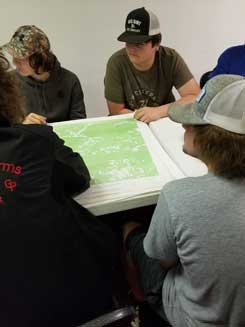 Picture of contestants looking at maps